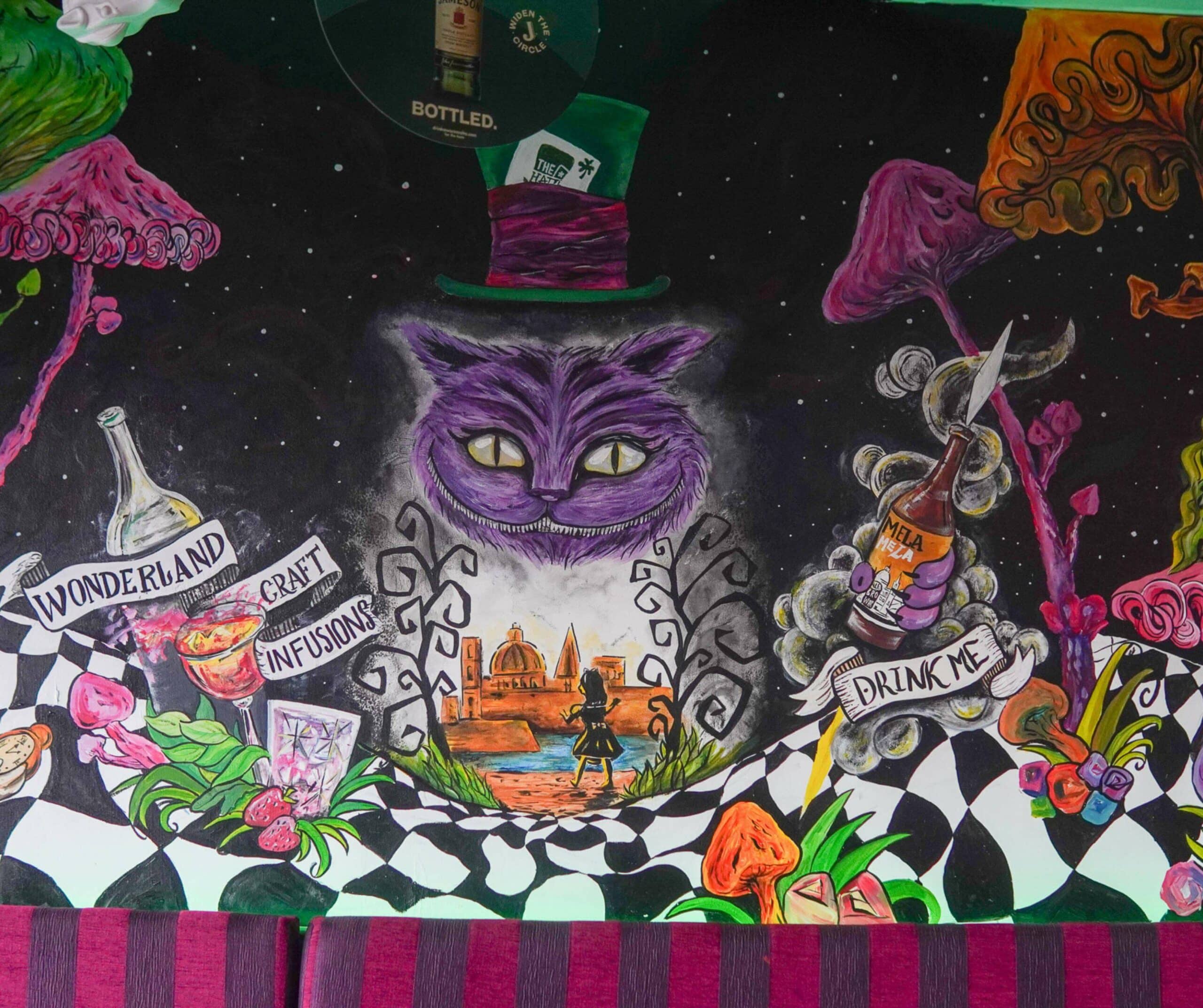 a mural of the cheshire cat in an alice in wonderland bar