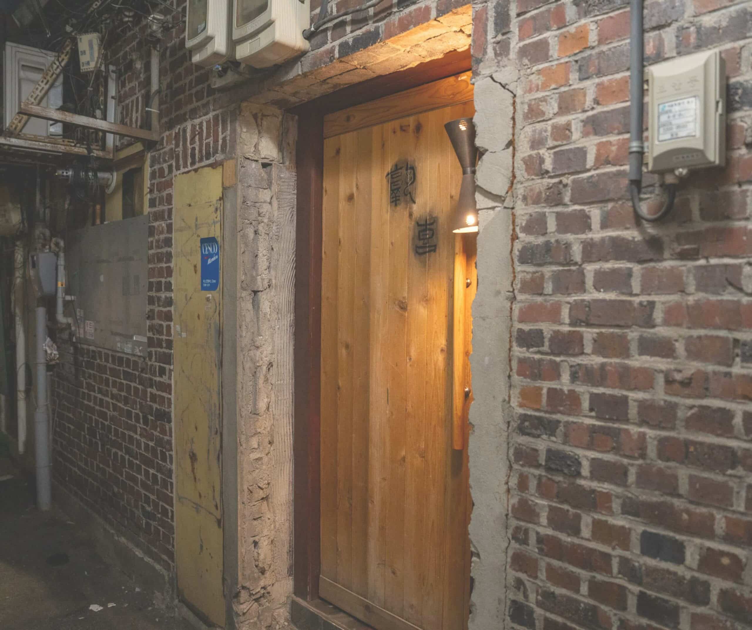The unassuming wooden door entrance to Bar Sookhee in Namsan, Seoul