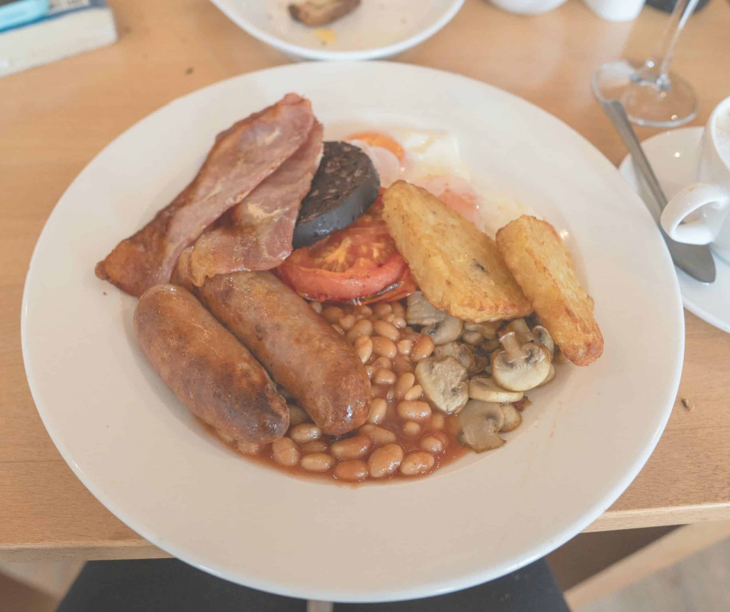 Full English breakfast at the Hope Anchor Hotel in Rye with sausages, bacon, black pudding, beans, mushrooms, hash browns, and egg