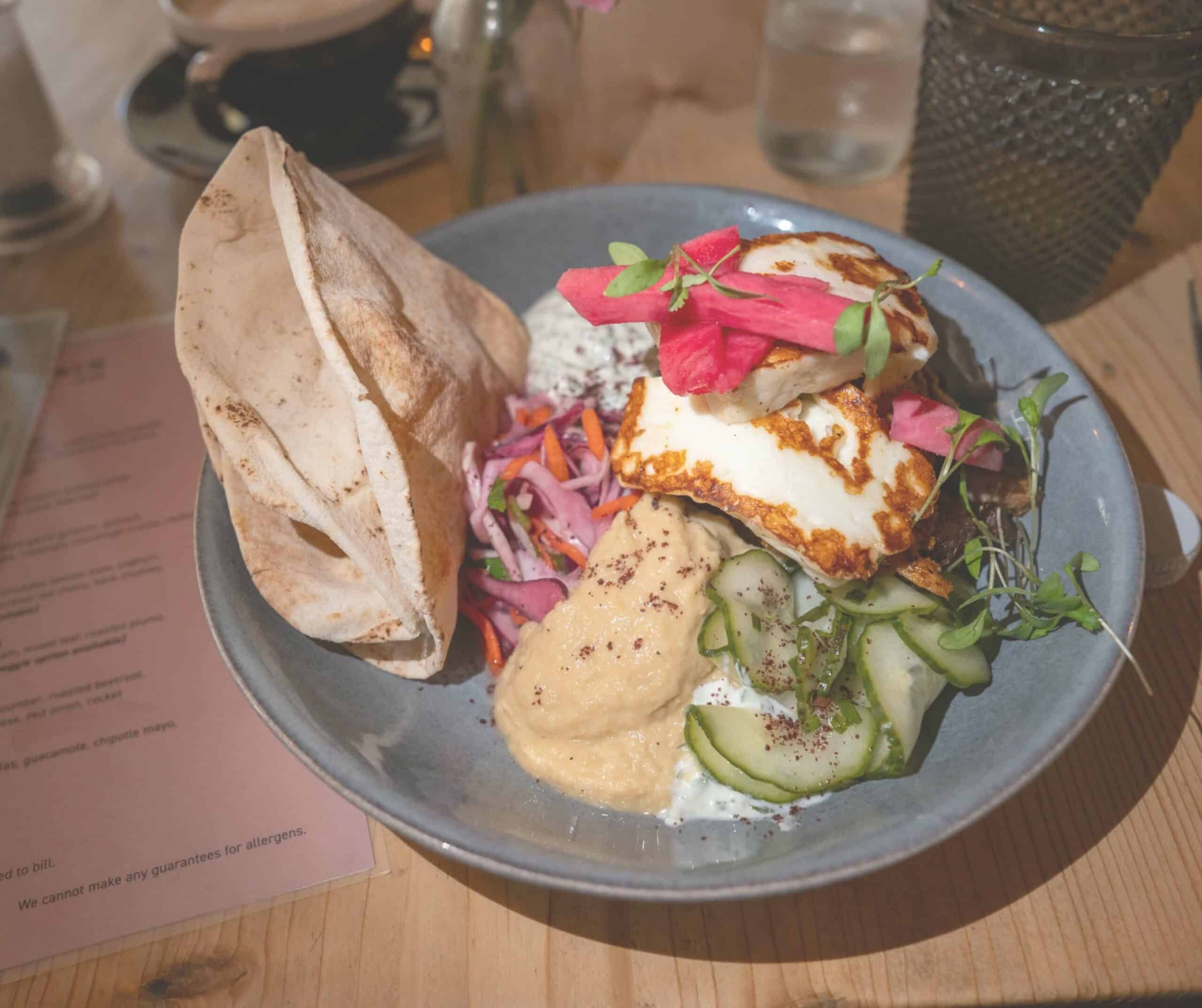 Halloumi small plate at The Fig in Rye with hummus, pita bread, pickled vegetables, cucumber, and slaw on a blue plate