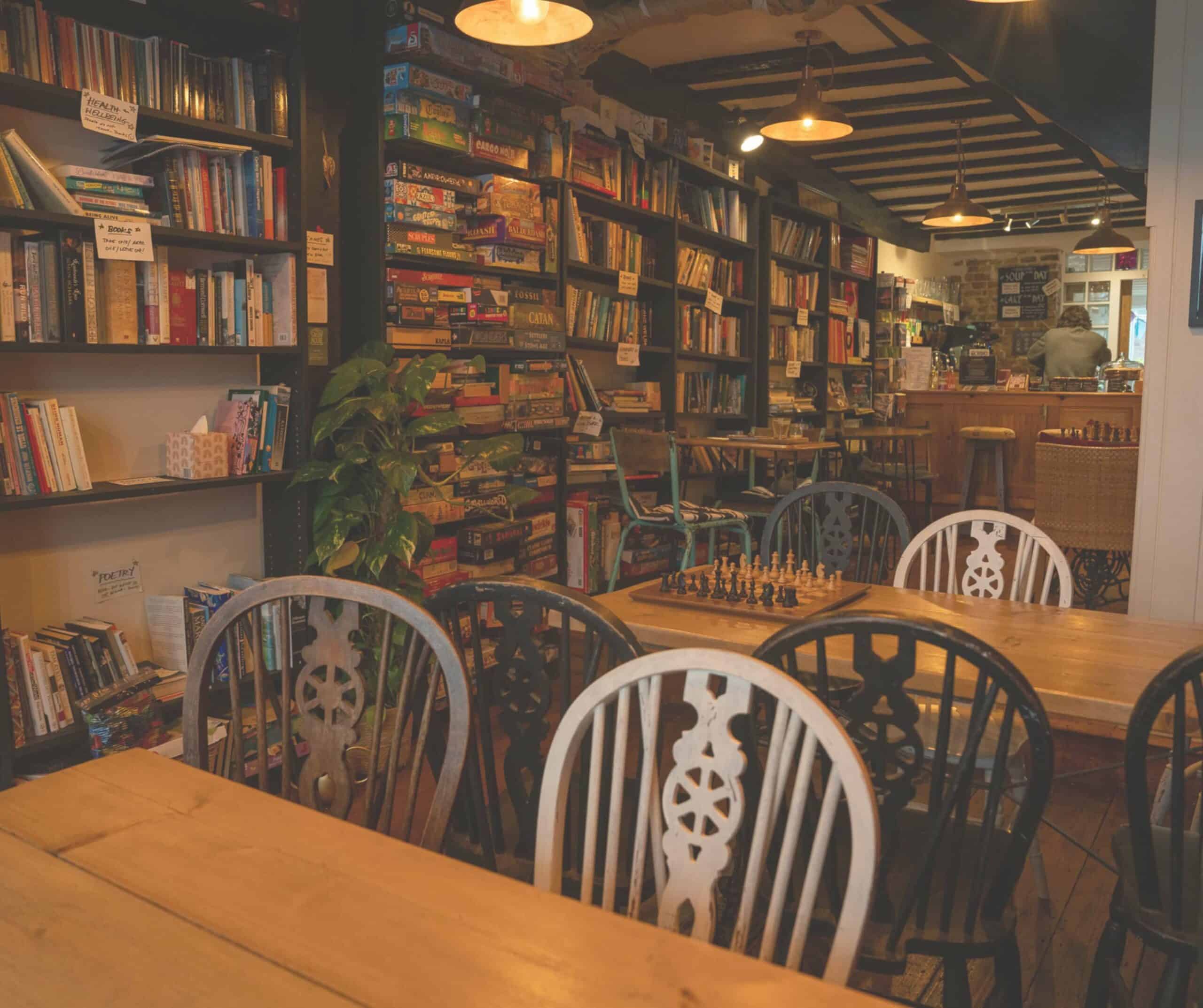 Cozy interior of Grounded cafe in Rye with shelves of books and board games, wooden tables, and a chess set