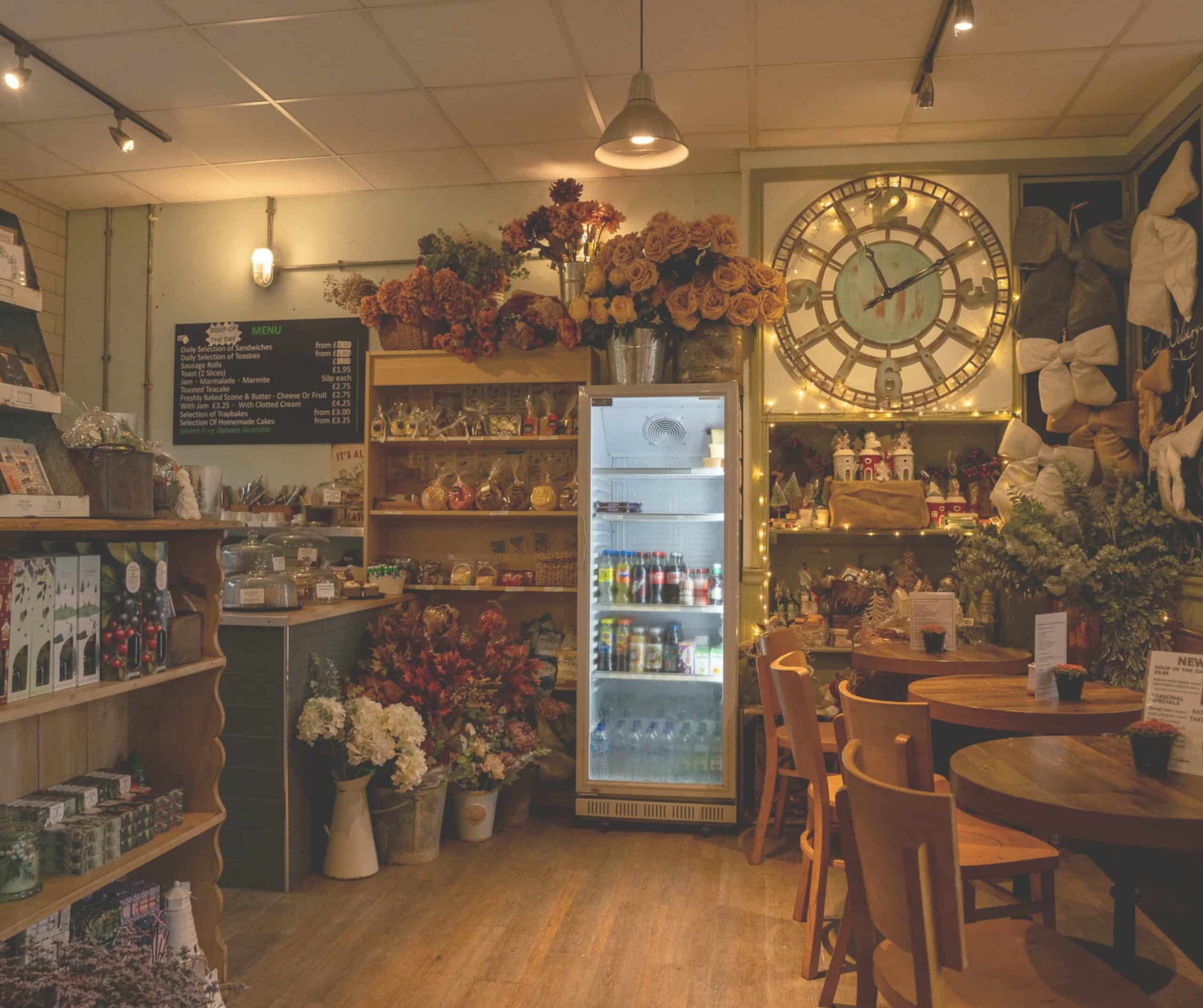 Cozy interior of Café des Fleurs in Rye filled with fresh flowers, gifts, a large clock, and wooden cafe tables
